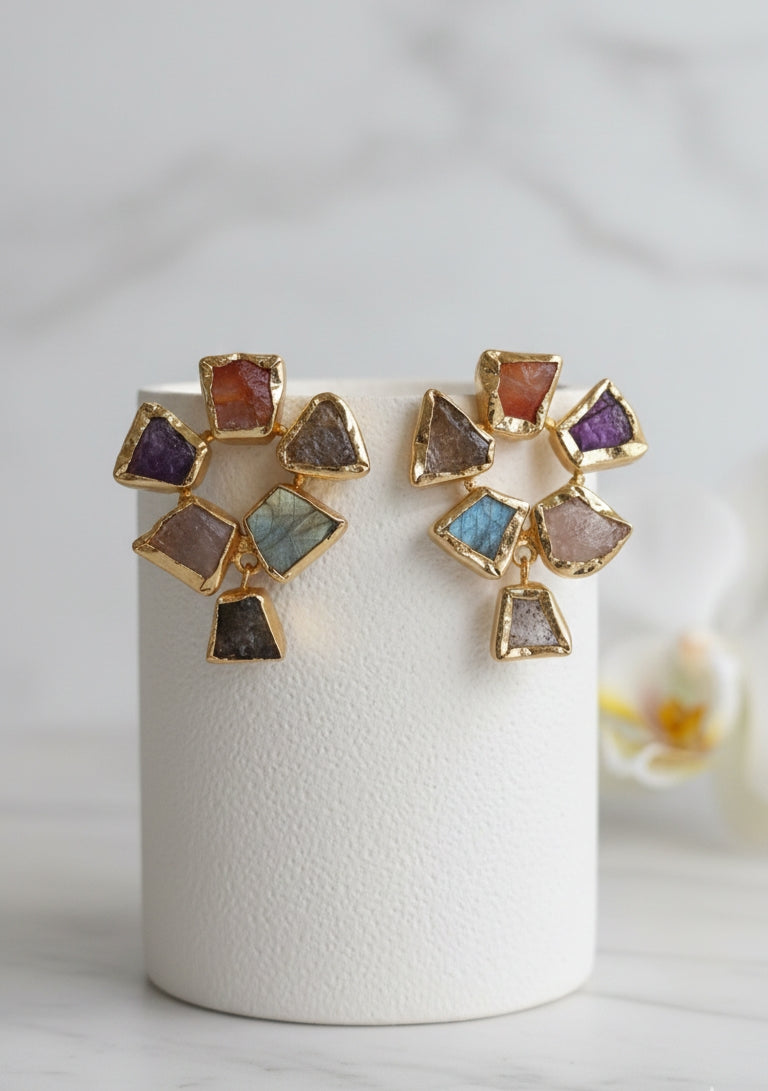 Pair of gold-plated earrings featuring rough-cut, multi-colored semi-precious stones arranged in a geometric fan shape with a dangling charm.